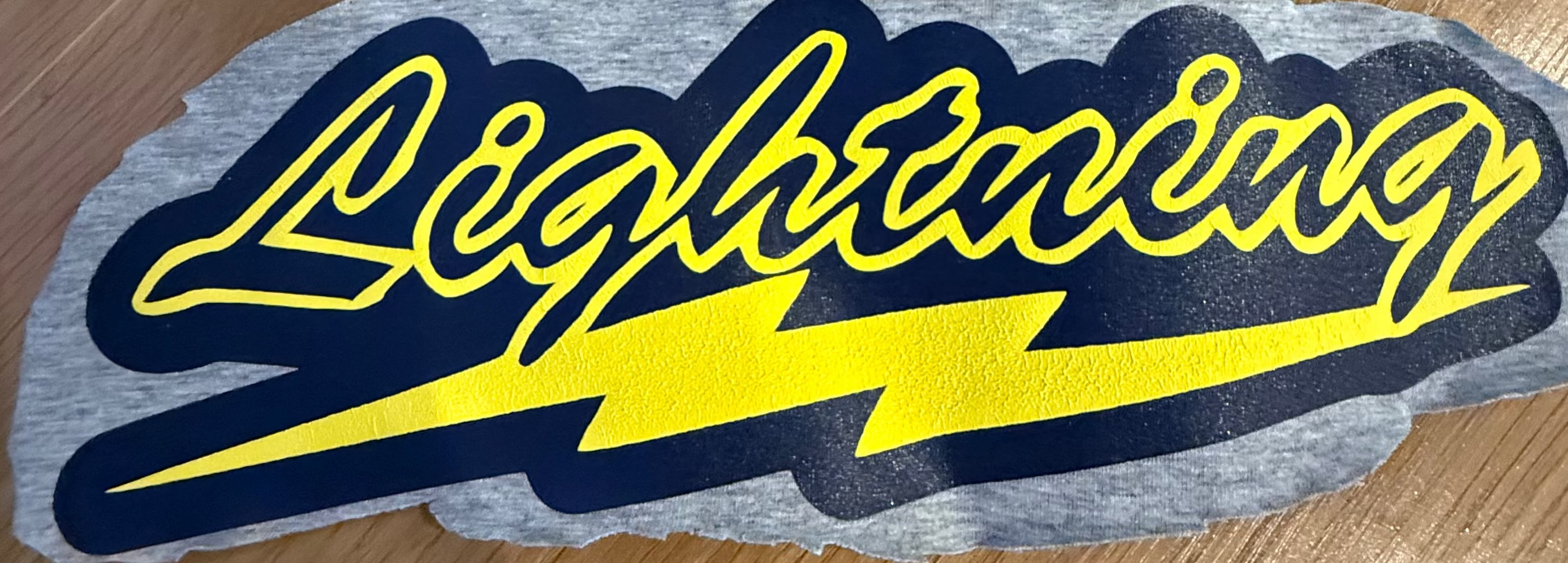 Logo swatch with 'Lightning' design on a wooden floor