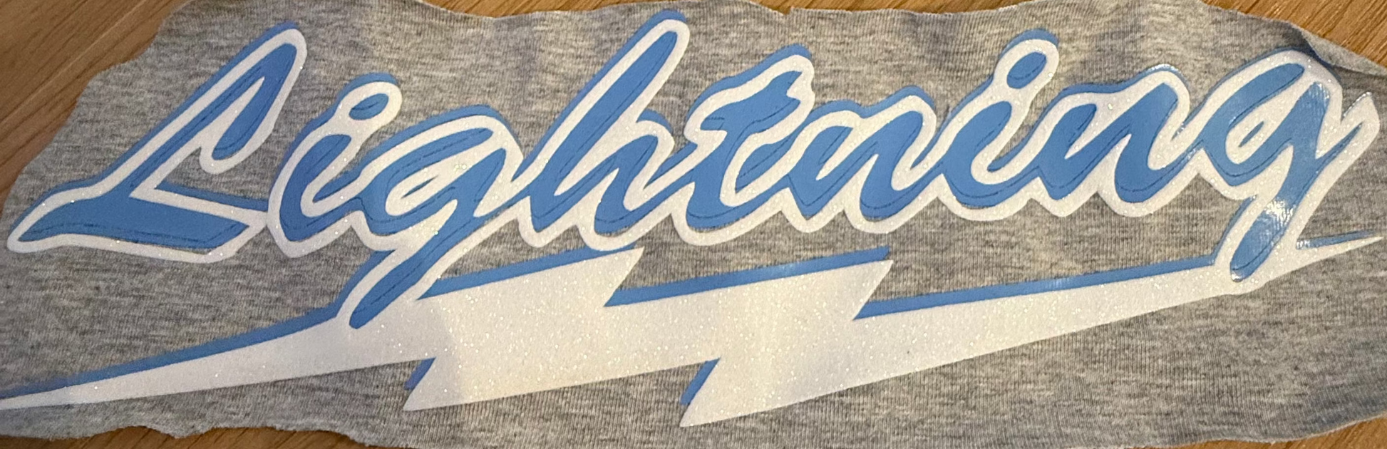 Logo swatch with 'Lightning' text on a wooden surface