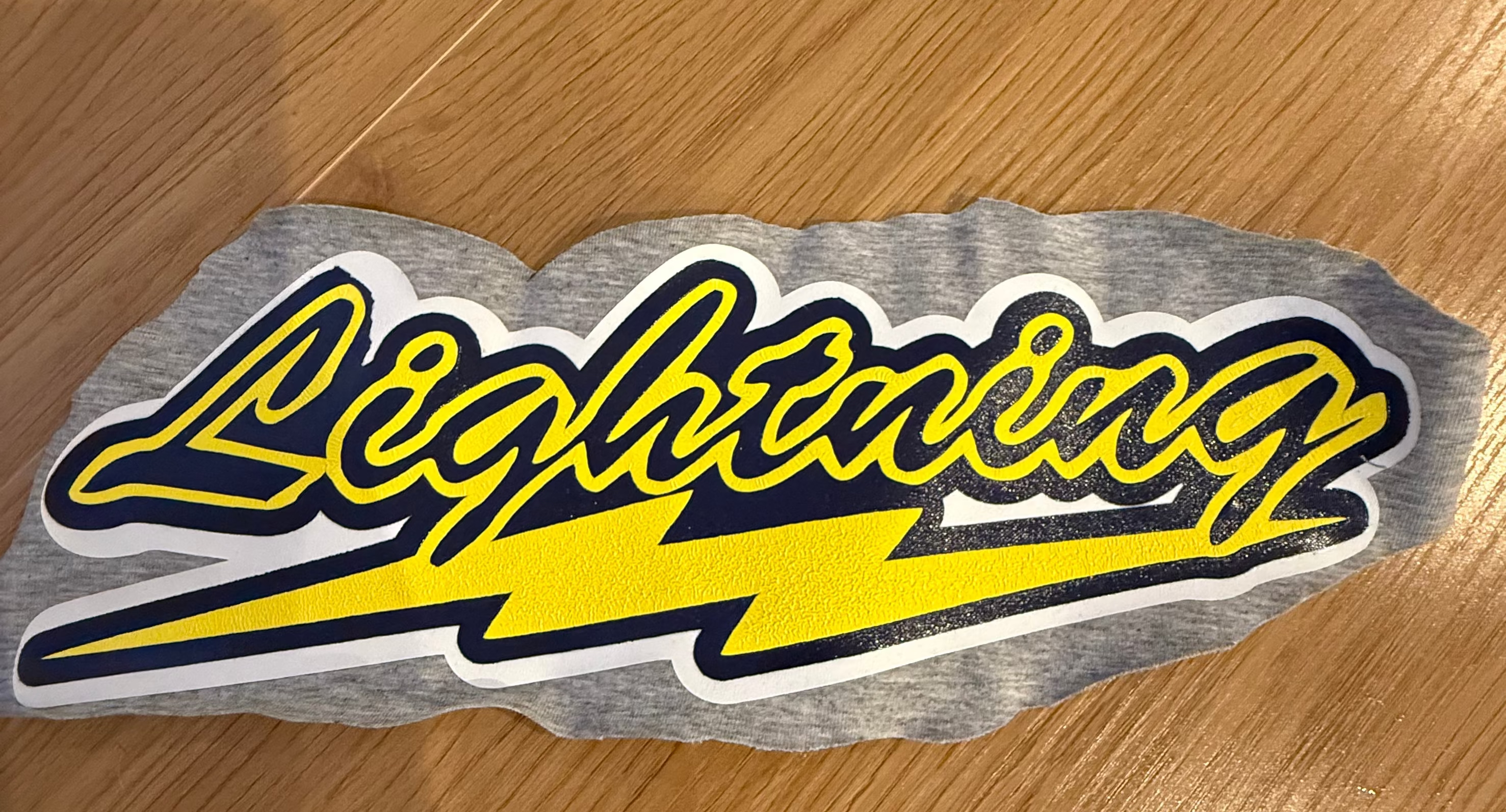 Logo swatch with 'Lightning' text and a bolt graphic on a wooden surface
